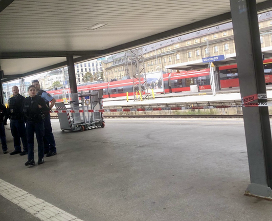 Bild aus einem Zug heraus. Zu sehen ist eine Plattform am Münchner Hauptbahnhof der mit Flatterband abgesperrt ist. Einige Polizeibeamt*innen stehen am Gleis.