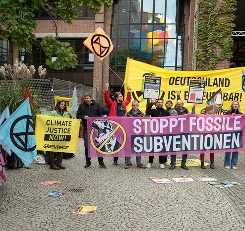 Aktivisti mit Bannern u. Fahnen vor dem Gasteig in München: Stoppt Fossile Subventionen